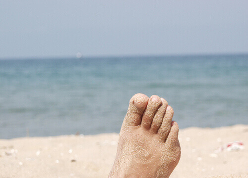Piasek przykleił się do stóp na plaży