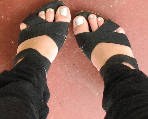 stopy w czarnych sandałach