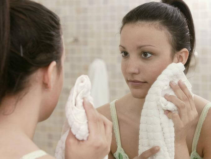 dziewczyna wyciera twarz ręcznikiem