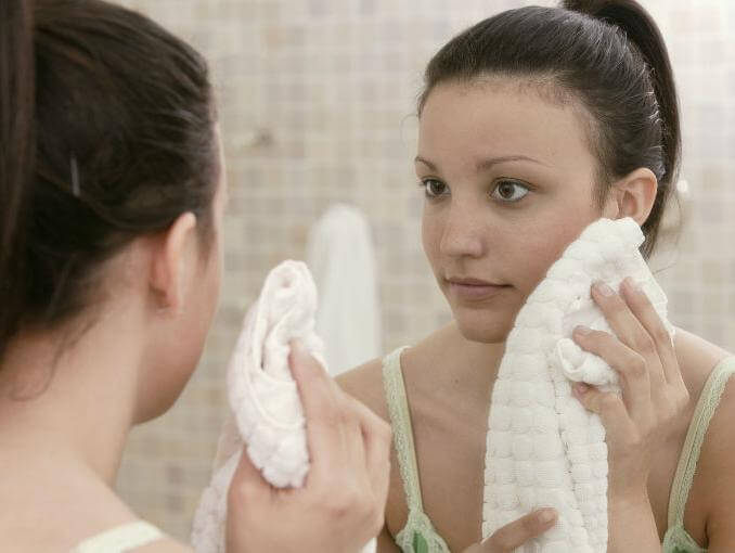 dziewczyna wyciera twarz ręcznikiem
