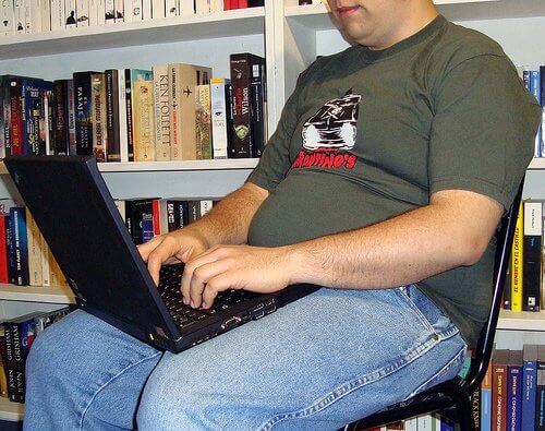 Otyły mężczyzna przy laptopie