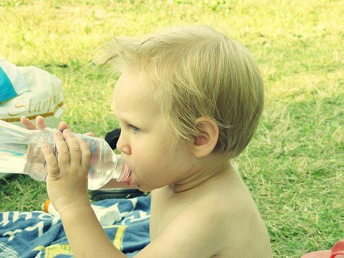 Dziecko pije z butelki - plastik w codziennym życiu