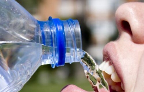 Kobieta pijąca wodę z plastikowej butelki