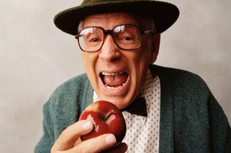 Starszy mężczyzna je jabłko