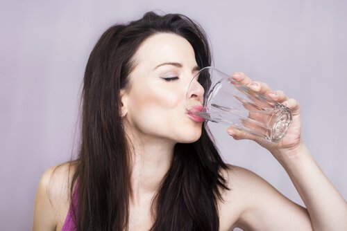 Kobieta pije wodę, by mieć zdrowe nerki