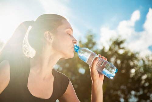Kobieta pije wodę z butelki