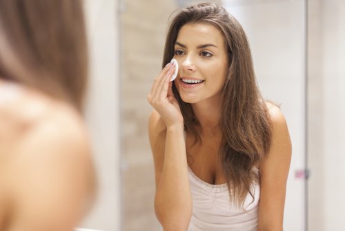 Kobieta oczyszcza skórę twarzy, by nałożyć krem ściagający