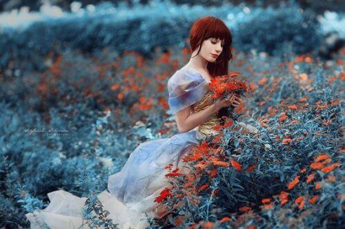 Zamyślona kobieta w polu czerwonych kwiatów