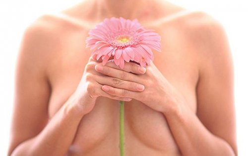 kwiatek trzymany przez kobietę