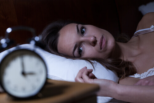 Kobieta w łóżku - bezsenność zakłócająca rytm snu