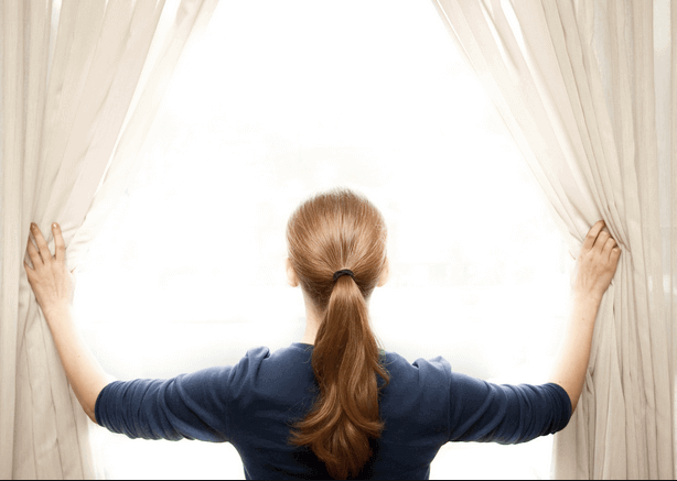 Kobieta odsłania okno