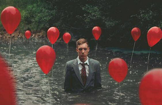 mężczyzna w wodzie z balonami
