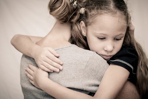 dziewczynka przytulona do matki