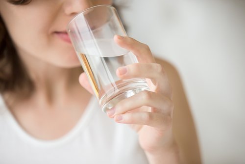 Kobieta pije wodę ze szklanki