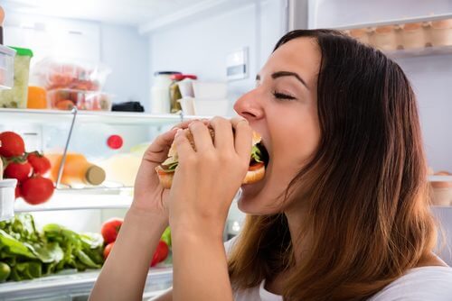 Głód psychiczny - kobieta jedząca hamburgera