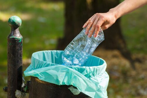 Butelka z plastiku wrzucana do kosza na śmieci
