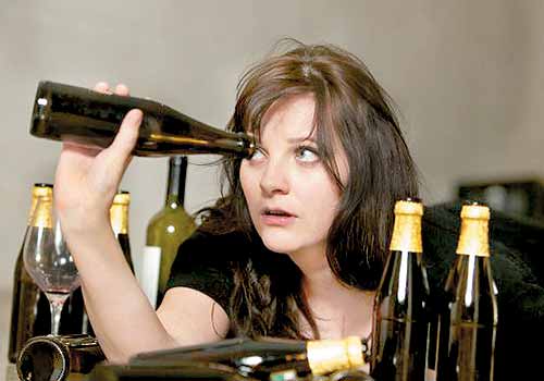 Dziewczyna zagląda do butelki - alkoholizm
