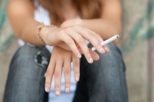 nastolatka pali papierosa - nastolatki i narkotyki