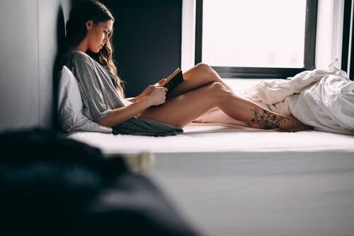 Kobieta w łóżku czyta książkę