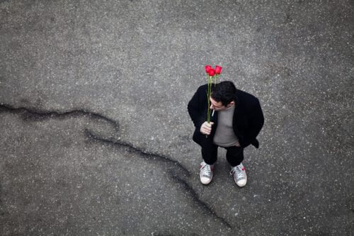 Mężczyzna czeka na ulicy z kwiatami