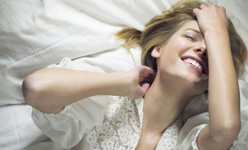 Uśmiechnięta kobieta w łóżku.
