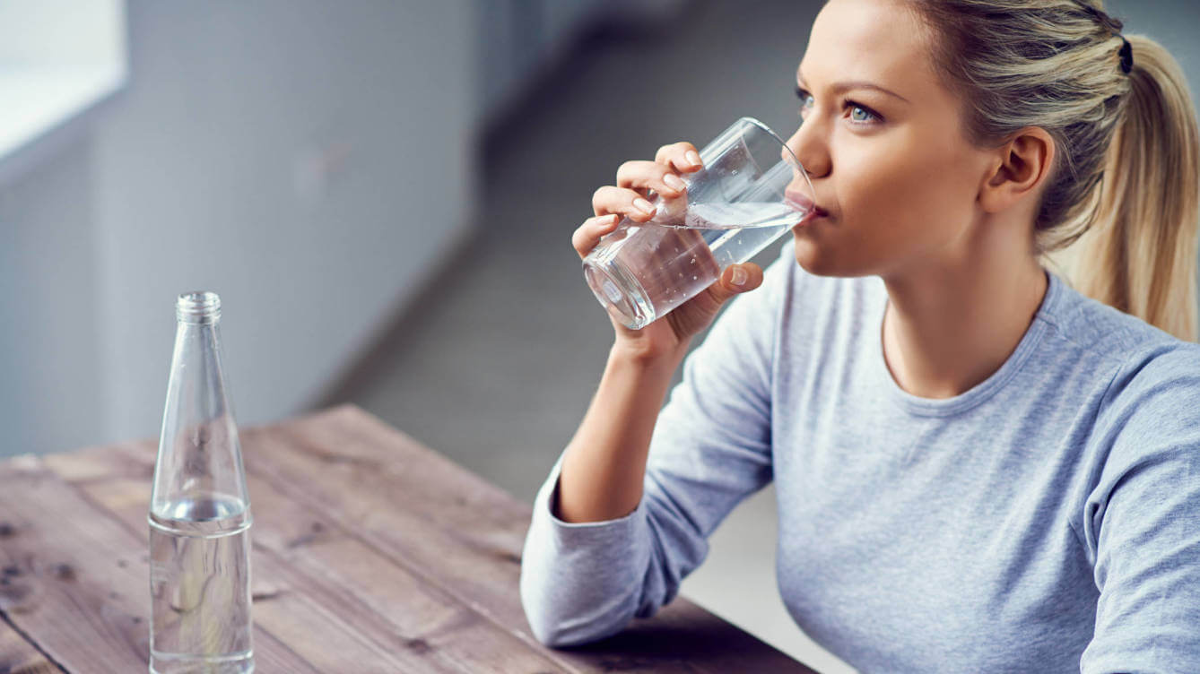 Kobieta pijąca wodę na lepsze krążenie krwi w nogach