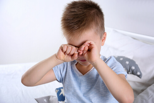 Chłopiec przecierający oczy chory na zespół aspergera