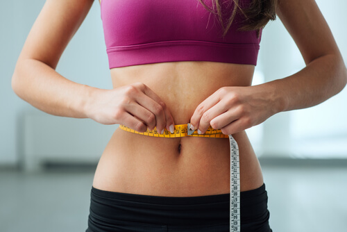 kobieta mierząca talię i odchudzająca się z garcinia cambogia