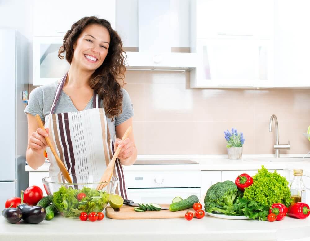 Gotująca kobieta. Zdrowe jedzenie zwalcza gazy jelitowe