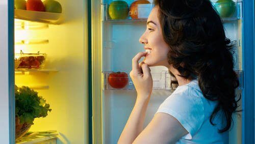 Podjadanie nawyki żywieniowe, kobieta przegląda lodówkę