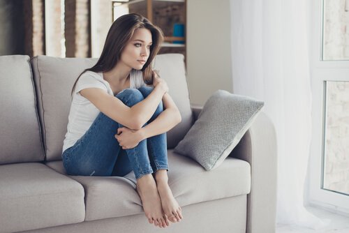 Kobieta siedzi na kanapie smutna
