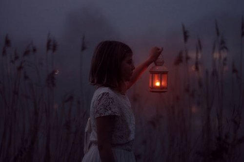 Dziewczynka z latarnią na łące wieczorem