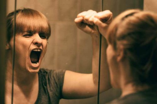 Cierpienie emocjonalne - kobieta krzyczy przed lustrem