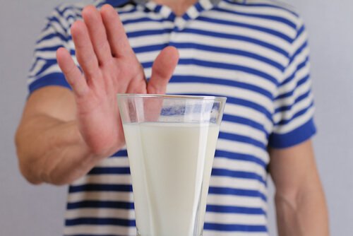 nietolerancja laktozy, Kobieta trzyma rękę na szklance mleka