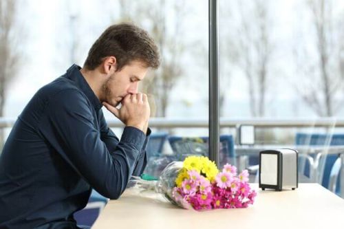 samotny mężczyzna z bukietem kwiatów - wyrzuty sumienia