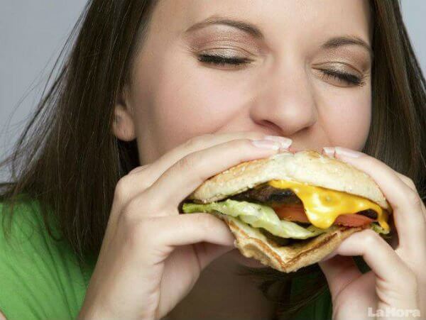 kobieta jedząca hamburgera