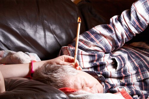 mężczyzna ze świeczką w uchu