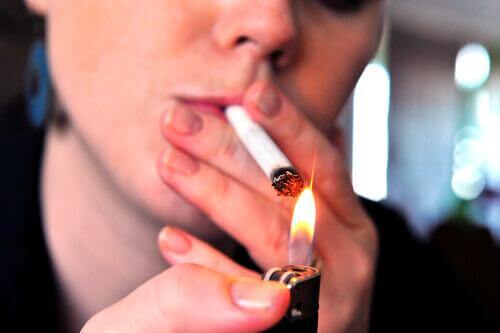 Palenie papierosów a rak płuc kobieta podpala papierosa