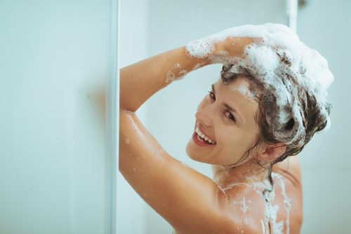 Kobieta myje głowę pod prysznicem