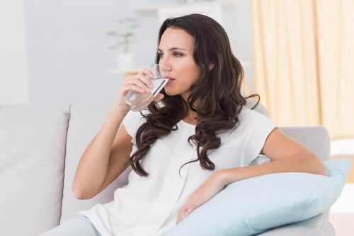 napoje zmniejszające stres, kobieta pije szklankę wody