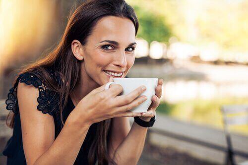 Kobieta pije kawę, by odzyskać energię