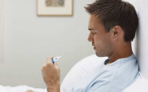 Mężczyzna patrzy na termometr temperatura