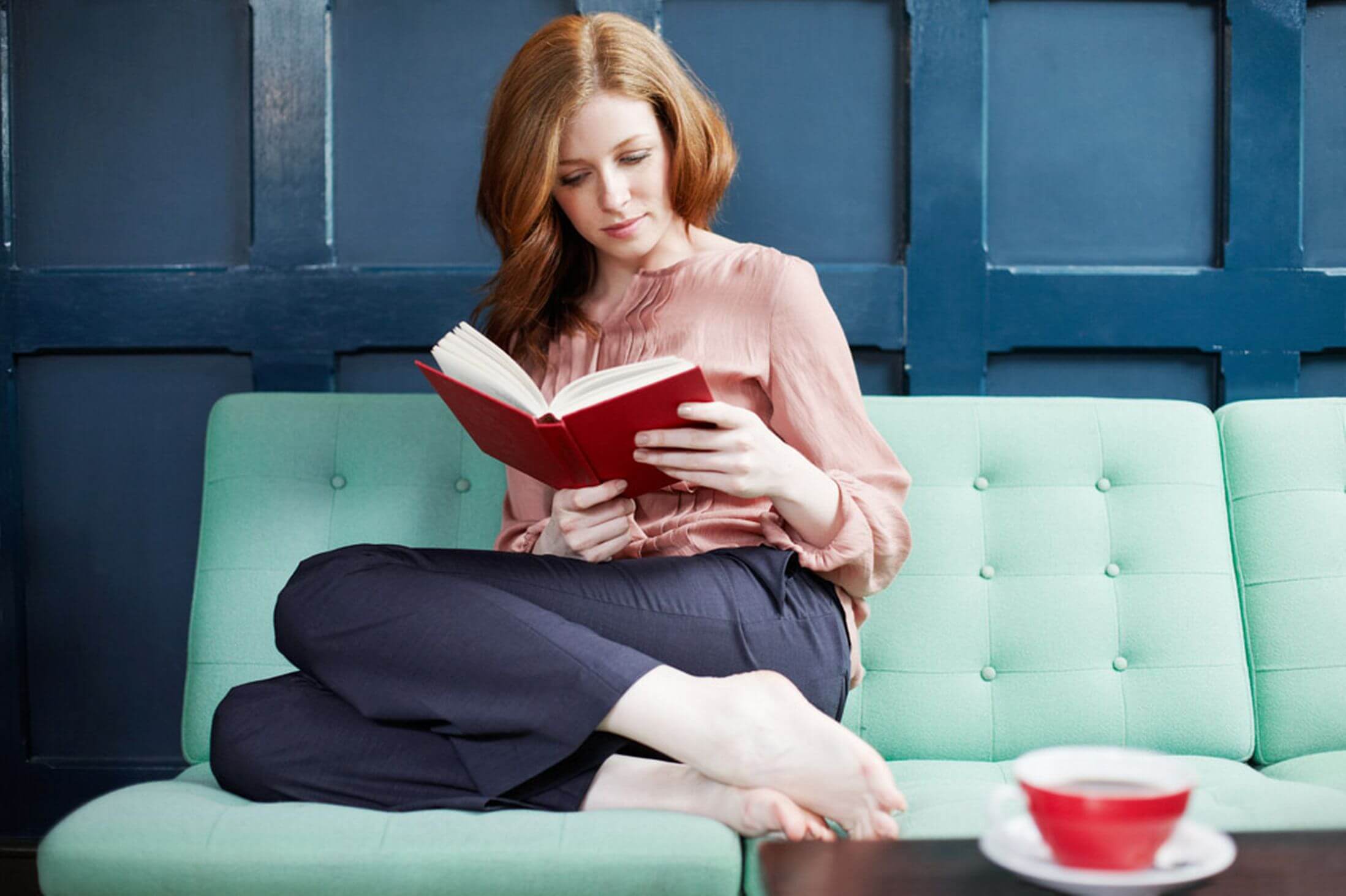 kobieta czytająca książkę na kanapie