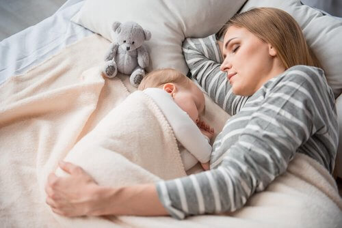 Mama i dziecko śpią razem.