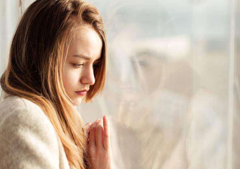 smutna kobieta przy oknie