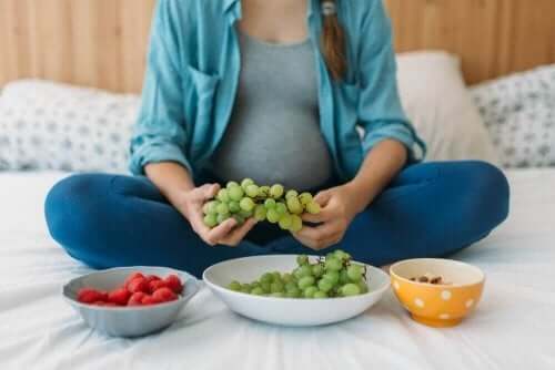 Kobieta w ciąży je owoce - bezpieczne leki w ciąży