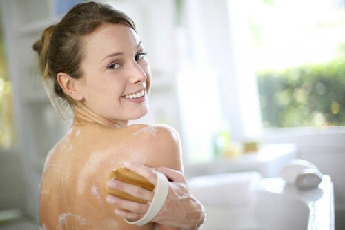 Kobieta myje piękne plecy bez trądziku