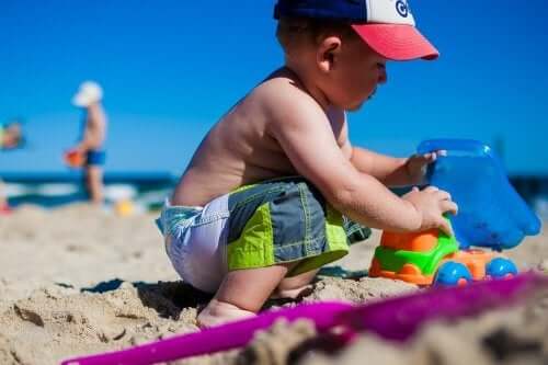 Chłopiec bawi się w piasku na plaży