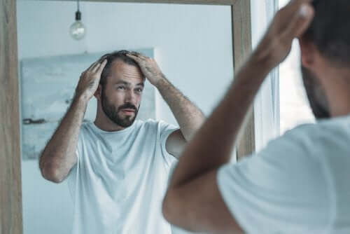 Mężczyzna sprawdza swoją łysinę - zabiegi z użyciem kurkumy mogą zatrzymać to zjawisko