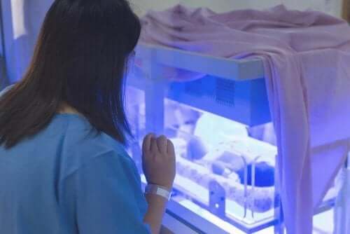 Kobieta patrząca na dziecko w inkubatorze